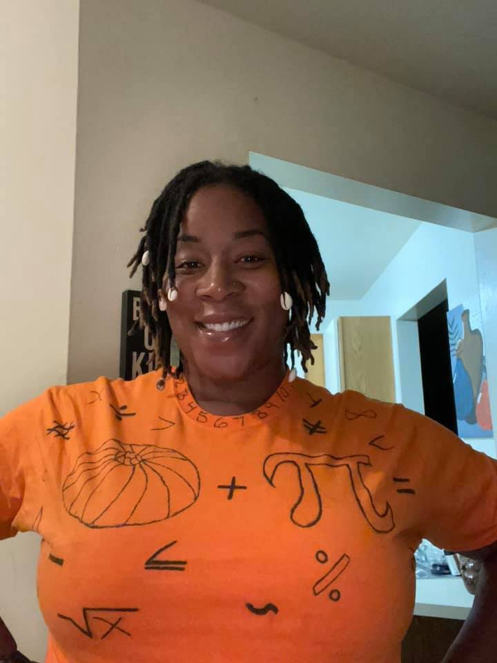Math teacher wearing shirt with pumpkin and mathematical symbol for pi