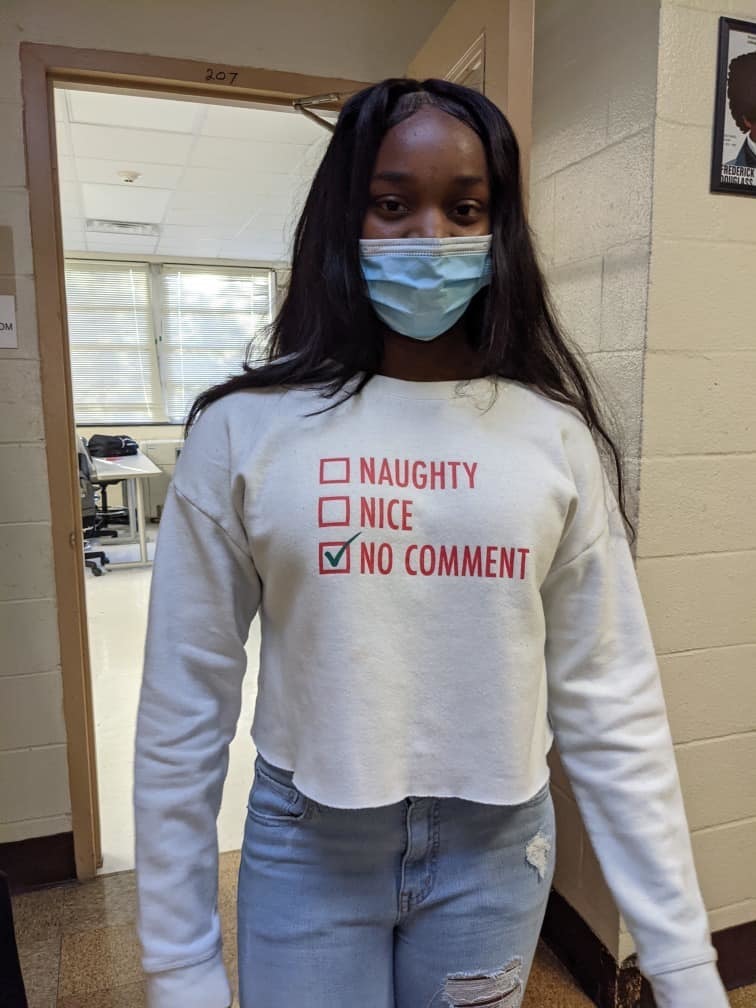 Student poses in hallway with positive shirt