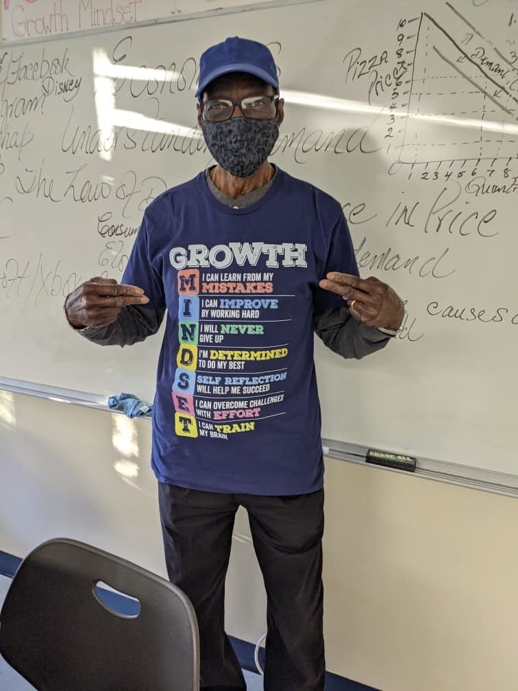 Teacher pointing to his Growth Mindset shirt